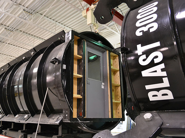 gray fire door mounted in a blast chamber for performance testing